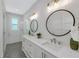 Modern bathroom with double vanity, quartz countertop, and patterned floor tiles at 3017 Avenue E, Holmes Beach, FL 34217