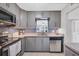 Modern kitchen with gray cabinets, tile backsplash, and stainless steel appliances at 3500 Beneva Rd # 303, Sarasota, FL 34232