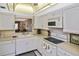 Condo kitchen with white cabinets, black appliances, and a pass-through at 365 Three Lakes Ln # G, Venice, FL 34285