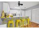 Bright kitchen features white cabinets, quartz countertops, and a breakfast bar with yellow stools at 4045 Oakhurst Dr # 3125, Sarasota, FL 34233