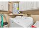 Bright laundry room, washer, dryer, cabinets, and water heater at 4045 Oakhurst Dr # 3125, Sarasota, FL 34233
