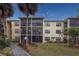Two-story condo building with screened balconies and lush landscaping at 425 30Th W Ave # C206, Bradenton, FL 34205