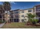 Two-story condo building with screened balconies and a grassy area at 425 30Th W Ave # C206, Bradenton, FL 34205