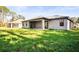 Large backyard with grassy lawn and a view of the home at 4497 N Salford Blvd, North Port, FL 34286