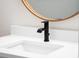 White vanity with a modern black faucet and a large round mirror at 4497 N Salford Blvd, North Port, FL 34286