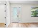 Bright entryway with modern frosted glass door and wood-look tile floors at 4497 N Salford Blvd, North Port, FL 34286