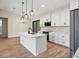 Modern kitchen with white cabinets, quartz countertops, and an island at 4497 N Salford Blvd, North Port, FL 34286