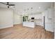 Open-plan kitchen with island, stainless steel appliances, and light wood flooring at 4497 N Salford Blvd, North Port, FL 34286