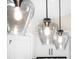 Closeup of three modern glass pendant lights above kitchen cabinets at 4497 N Salford Blvd, North Port, FL 34286