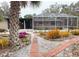 Brick pathway leads to a screened patio and pool area, nestled in a tropical garden at 5353 Shadow Lawn Dr, Sarasota, FL 34242