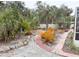 Landscaped backyard with a brick pathway winding through tropical plants and trees at 5353 Shadow Lawn Dr, Sarasota, FL 34242