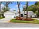 White single-story home with a two-car garage and landscaped yard at 5575 Beneva Woods Cir, Sarasota, FL 34233