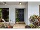 Black front door with tiled entryway and potted plants at 5575 Beneva Woods Cir, Sarasota, FL 34233