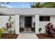 Modern front entrance with black wrought iron gates and landscaping at 5575 Beneva Woods Cir, Sarasota, FL 34233