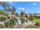 Community pool, patio tables, lush landscaping, and a surrounding fence at 6238 7Th W Ave # 6238, Bradenton, FL 34209