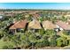 Aerial view of a community with houses, palm trees and a lake at 6739 Haverhill Ct, Lakewood Ranch, FL 34202