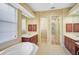 Elegant bathroom with double vanities, a soaking tub, and a separate shower at 7939 Treesdale Gln, Lakewood Ranch, FL 34202