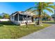 Single-wide mobile home with covered porch, palm tree, and well-maintained lawn at 808 53Rd E Ave # 226L, Bradenton, FL 34203