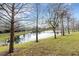 Serene pond view with lush green grass and mature trees at 8908 White Sage Loop, Lakewood Ranch, FL 34202