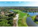Aerial view of a lush golf course with houses and a lake at 9711 Sea Turtle Ter # 102, Bradenton, FL 34212