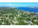 Wide aerial view showcasing a neighborhood near a body of water with lush green surroundings at 104 24Th Ne St, Bradenton, FL 34208
