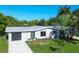 Updated single-story home with gray exterior, showcasing a modern garage door and landscaping at 104 24Th Ne St, Bradenton, FL 34208