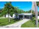 Modern, single-story home with a gray exterior, landscaped yard, and a long driveway at 104 24Th Ne St, Bradenton, FL 34208