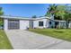 Updated home exterior boasts a modern gray facade, driveway, and landscaped lawn at 104 24Th Ne St, Bradenton, FL 34208
