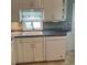 White kitchen cabinets, gray countertops, and a dishwasher at 1111 42Nd E Ave, Ellenton, FL 34222