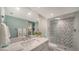 Modern bathroom with glass shower, marble vanity and floors, and stacked washer and dryer nearby at 1111 N Gulfstream Ave # 4E, Sarasota, FL 34236