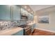 Kitchen with updated stainless steel appliances, a cooktop, and blue cabinets at 1111 N Gulfstream Ave # 4E, Sarasota, FL 34236
