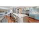 Modern kitchen features light blue cabinets, stainless steel appliances, a breakfast bar with white marble countertops, and hardwood floors at 1111 N Gulfstream Ave # 4E, Sarasota, FL 34236