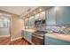 Modern kitchen boasting stainless steel appliances, light blue cabinets, mosaic backsplash and marble countertops at 1111 N Gulfstream Ave # 4E, Sarasota, FL 34236
