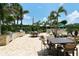 Outdoor kitchen area with grills, tables, and seating amongst tropical landscaping at 1111 N Gulfstream Ave # 4E, Sarasota, FL 34236