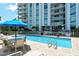 Bright and sunny community pool with patio furniture and umbrellas at 1111 N Gulfstream Ave # 4E, Sarasota, FL 34236