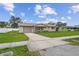 Tan single story house with attached garage and neatly landscaped yard at 1215 E Venice Ave, Venice, FL 34285