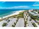 Aerial view of beach, parking lot, and coastal homes at 129 Tyler Dr # 101, Sarasota, FL 34236