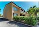 Tan colored building exterior with lush landscaping and palm trees at 129 Tyler Dr # 101, Sarasota, FL 34236