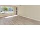 Spacious living room with large window and light wood-look floors at 129 Tyler Dr # 101, Sarasota, FL 34236
