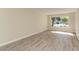 Bright and airy living room with large window and wood-look flooring at 129 Tyler Dr # 101, Sarasota, FL 34236