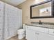 Well-lit bathroom with a modern vanity and shower with curtain at 1382 Ronald St, North Port, FL 34286