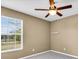 Bright bedroom with a large window, neutral-colored walls, and a ceiling fan at 1382 Ronald St, North Port, FL 34286