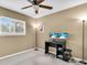 Bedroom with a ceiling fan, natural light from the window, and a desk with computer monitors at 1382 Ronald St, North Port, FL 34286