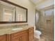 Bathroom with granite countertop, wood cabinets and a glass shower at 1389 Tangier Way, Sarasota, FL 34239