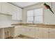 Bright laundry room with white cabinets and granite countertops at 1389 Tangier Way, Sarasota, FL 34239
