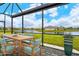Relaxing screened patio overlooking a lake with seating for six at 15910 Clear Skies Pl, Bradenton, FL 34211