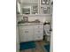 Bathroom with white vanity, granite top, and teal accents at 1603 Gulf N Dr # 27, Bradenton Beach, FL 34217