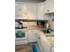White kitchen with granite counters, stainless appliances, and wood flooring at 1603 Gulf N Dr # 27, Bradenton Beach, FL 34217