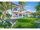 Two-story home with pool, turf lawn, and lounge chairs; idyllic backyard oasis at 1707 Palma Sola Blvd, Bradenton, FL 34209