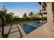 Lighted pool at dusk with a view of the backyard at 1707 Palma Sola Blvd, Bradenton, FL 34209